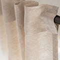 Close-up texture of natural unbleached linen fabric showing organic weave pattern