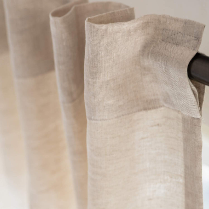 Close-up texture of natural unbleached linen fabric showing organic weave pattern