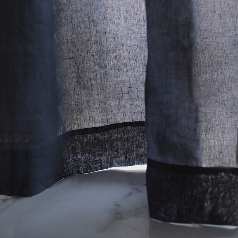 Close-up texture of handwoven charcoal linen curtain fabric showing natural weave