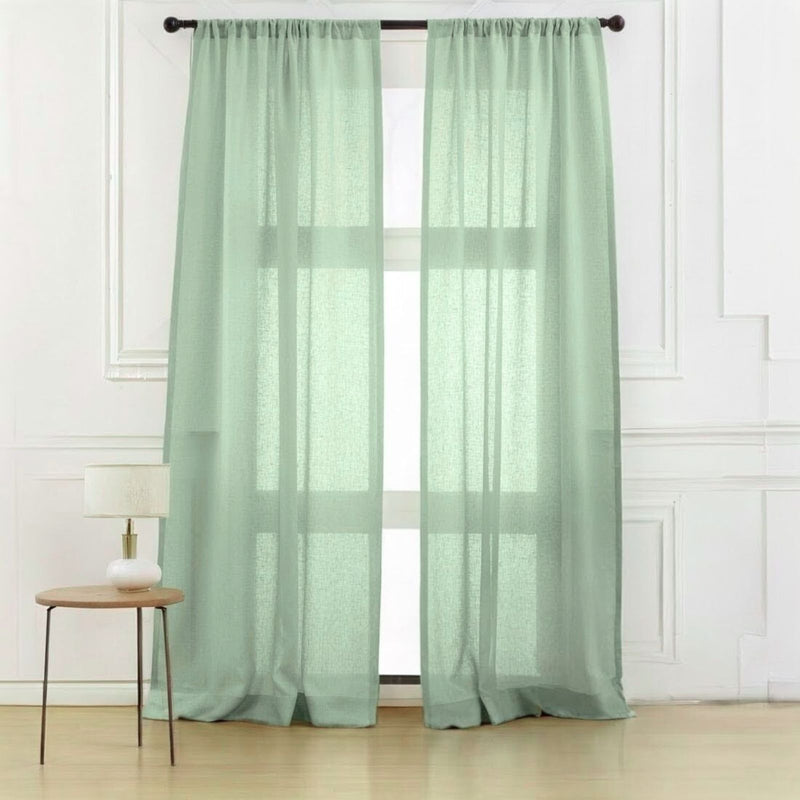 Sage green linen curtains in serene bedroom creating spa-like atmosphere with wooden furniture