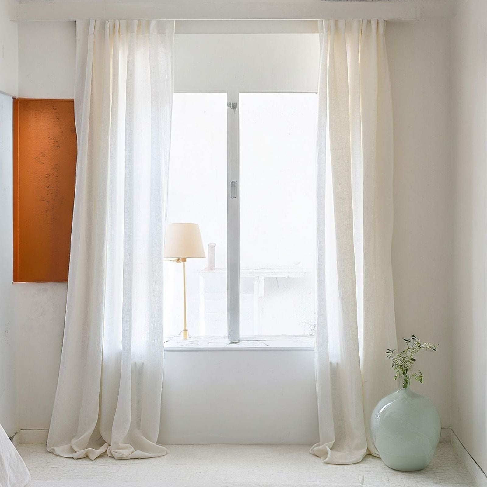 Off white linen curtains hanging in modern living room with natural light
