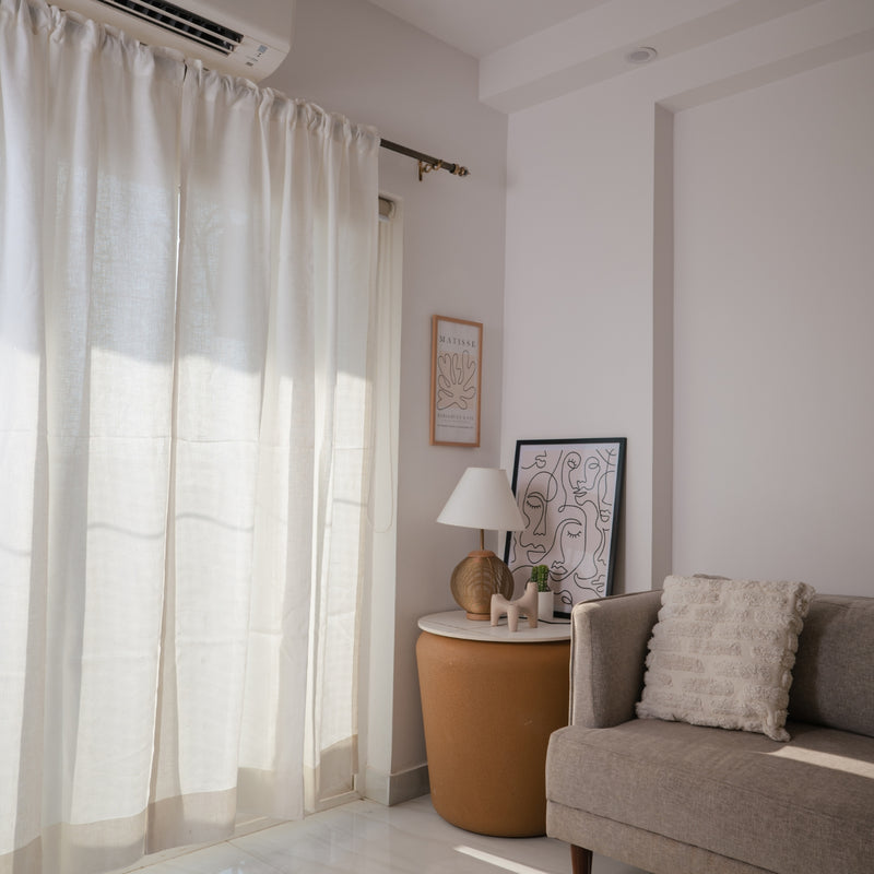Off white semi-sheer linen curtains in bedroom creating soft morning light