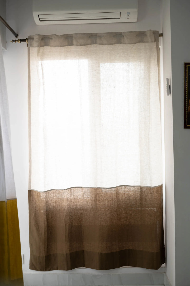 Natural light filtering through semi-sheer color-blocked linen curtains in bedroom setting