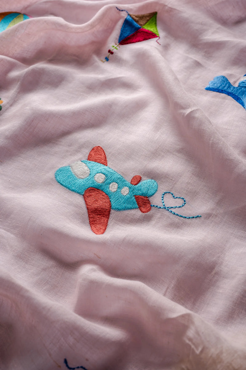 Soft pink embroidered linen nursery curtains with colorful birds and airplanes in children's room
